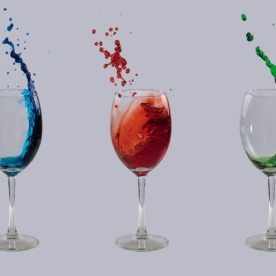 Roland Seichter Fotografie - Experimentelle Fotografie - 3 Gläser mit jeweils Flüssigkeit in blau, rot und grün, die aus dem Glas schwappen.