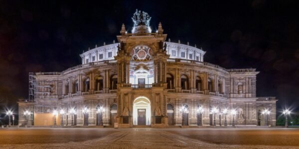 Semperoper Dresden bei Nacht, beleuchtet und mit neoklassischer Architektur.