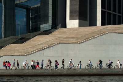 Roland Seichter Fotografie - Städtefotografie - Composing mehrerer Fotos zu einem. viele Passanten zu Fuß oder auf dem Fahrrad vor einer großen Treppe