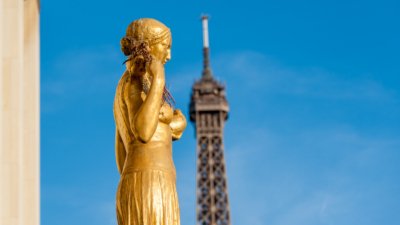 Roland Seichter Fotografie - Städtefotografie - Paris - Einer goldenen Statuen auf dem Trocadero, die Spitze des Eiffelturms im Hintergrund