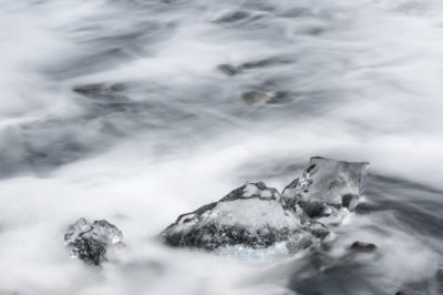 Roland Seichter Fotografie - Abstrakte Fotografie - Eisstücke umspült von Meerwasser. Die Langzeitbelichtung erzeugt einen Verwischungseffekt auf dem Wasser