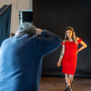 Roland Seichter Fotografie - Ein Fotograf in einem Studio fotografiert ein Modell im roten Kleid