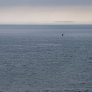 Roland Seichter Fotografie - Einzigartige Wandbilder - Fotografie mit Wasser - Blick über das Meer, der Horizont ist unscharf im Nebel. Im Vordergrund ein kleines Segelboot