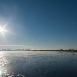 Roland Seichter Fotografie - Einzigartige Wandbilder - Landschaftsfotografie - Gegenlichtaufnahme mit einem See im Vordergrund