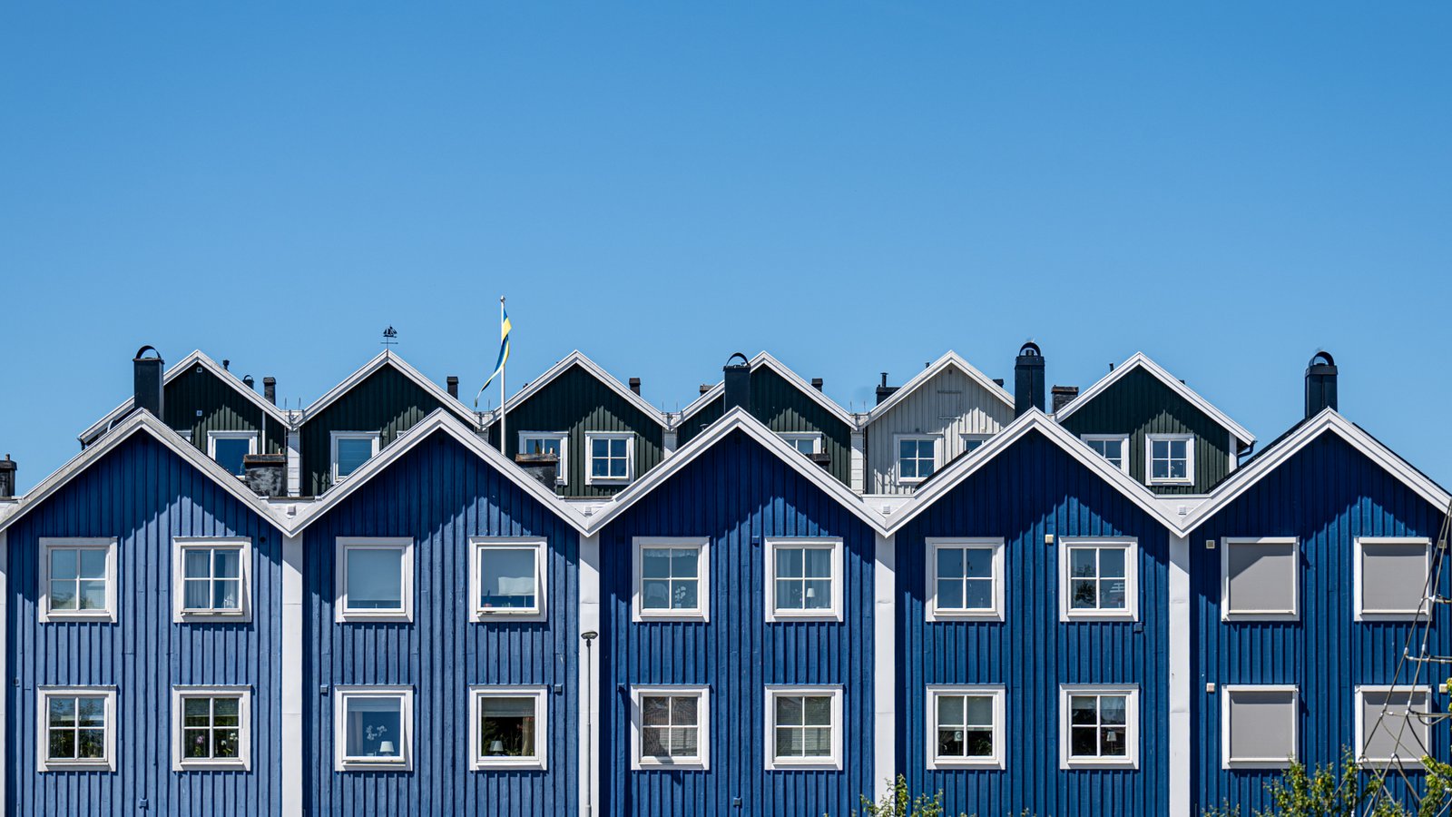 Roland Seichter Fotografie - Architekturfotografie - Aufnahme von mehreren schwedischen Holzhäusern. Alle mit bleuer Fassade