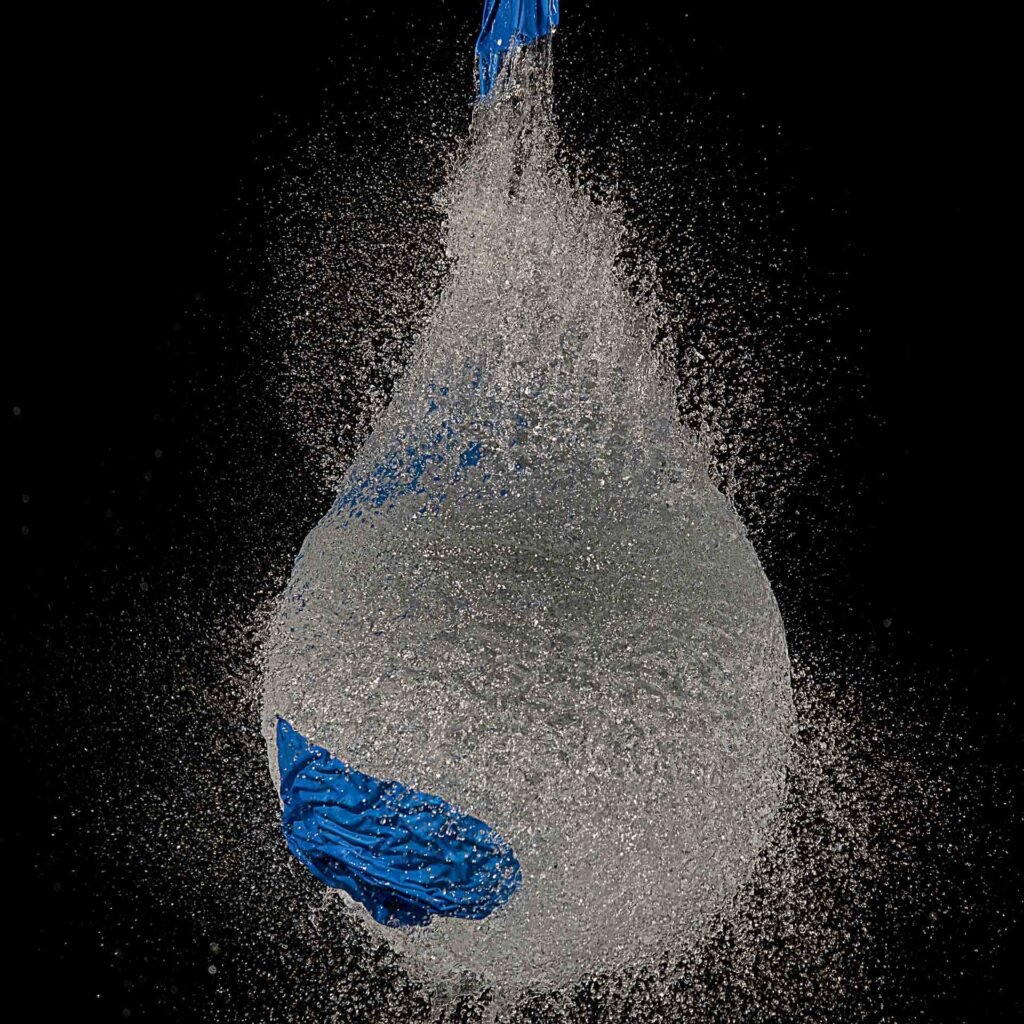 Roland Seichter Fotografie - Experiment - Ein mit Wasser gefüllter blauer Luftballon wird zum Platzen gebracht und genau im Moment des Platzens fotografiert.