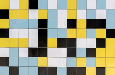 Roland Seichter Fotografie - Abstrakte Fotografie - Bild einer mit quadratischen Fliesen gefliesten Wand, die Fliesen sind weiß, schwarz, gelb und hellblau