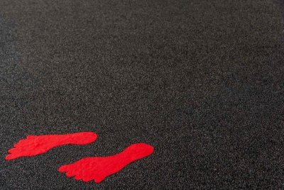 Roland Seichter Fotografie - Fotowettbewerbe - Ein antrhrazitener Fußboden, auf dem zwei Fußabdrücke in rot aufgeklebt sind