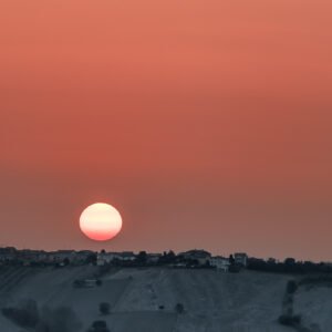 Roland Seichter Fotografie - Einzigartige Wandbilder - Landschaftsfotografie - Sonnenaufgangsbild einer rötlichen Sonne über einem Hügel