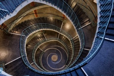 Roland Seichter Fotografie - Einzigartige Wandbilder - Architekturfotografie -Fotografie eines Treppenhauses von oben betrachtet. Die gemoetrische Faszination dieser Architektur macht das Bild aus