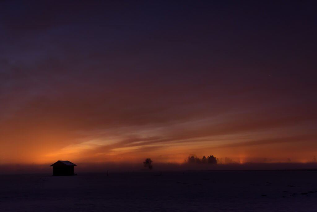 Roland Seichter Fotografie - Landschaftsfotografie - Sehr dunkel gehaltenes Bild einer Landschaft mit dunklem Vordergrund und dunklem Himmel, nur noch ganz wenig oranges Licht am Horizont