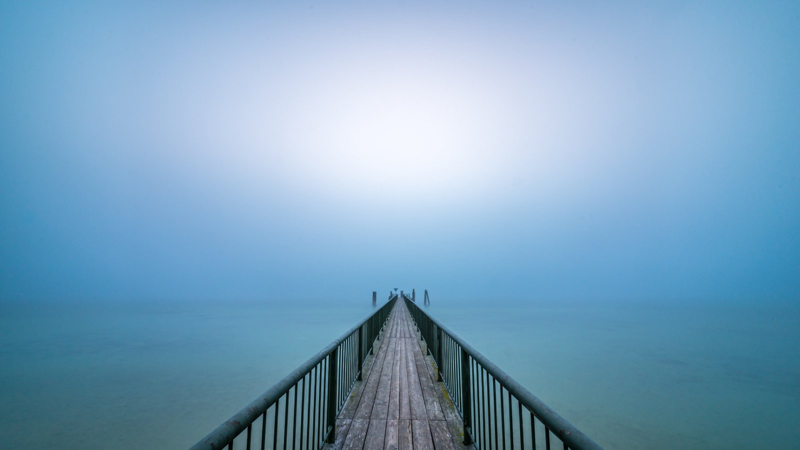 Roland Seichter Fotografie - Minimalistische Fotografie - Ein Dampfersteg am Ammersee führt in die Mitte des Bildes