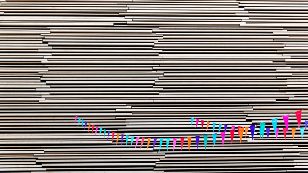 Roland Seichter Fotografie - Minimalistische Fotografie - Bunte Fähnchen vor einem Schwarz/Weißen Hintergrund