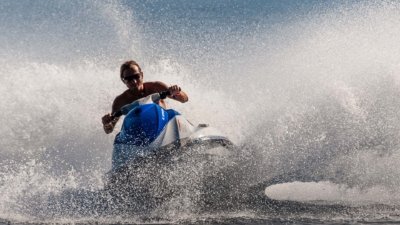 Roland Seichter Fotografie - Sportfotografie - Ein Wasserbob von vorn fotografiert, der Fahrer hat Spaß, er lächelt, Das Wasser spritzt in allen Richtungen