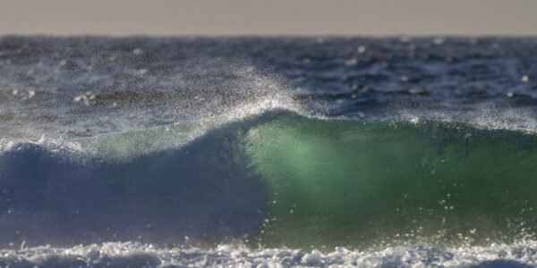 Roland Seichter Fotografie - Einzigartige Wandbilder - Fotografie mit Wasser - Fotografie einer Meerwelle, die Gischt wird vom Wind nach oben getrieben