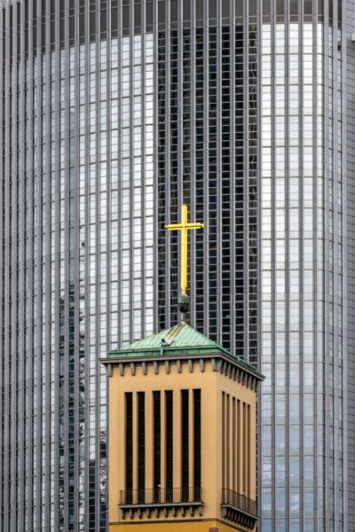 Roland Seichter Fotografie - Städtefotografie - Frankfurt - Der Trum einer Kirche mit einem Kreuz auf der Turmspitze. Im Hintergrund die Fensterfassade eines Hochhauses