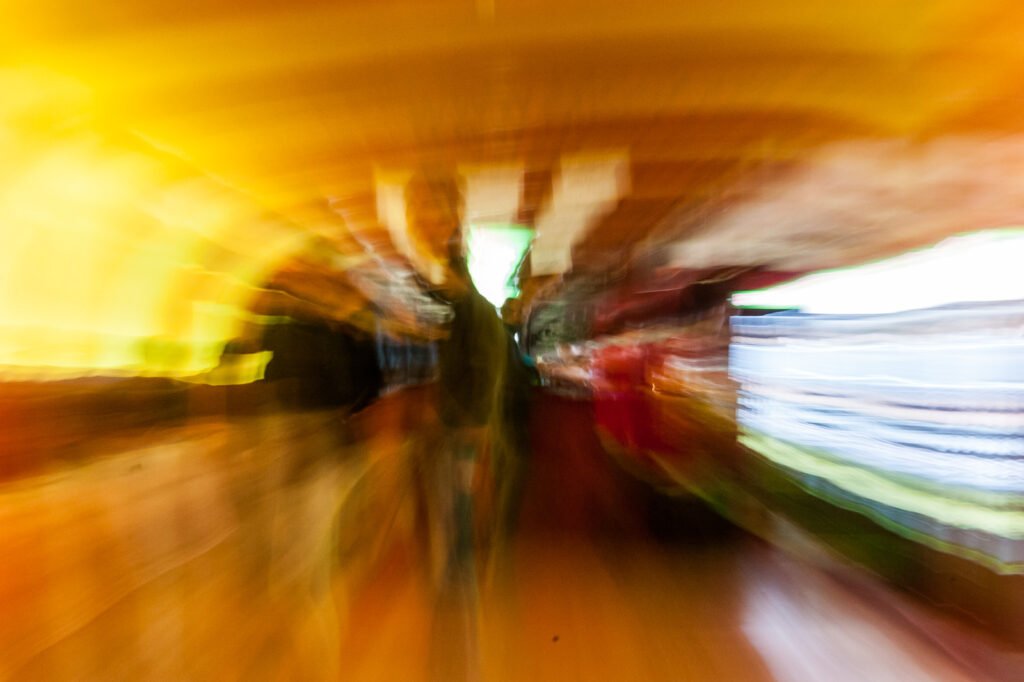 Abstrakte Fotografie mit radialer Bewegungsunschärfe in warmen Gelb- und Goldtönen mit kontrastierenden dunklen Akzenten