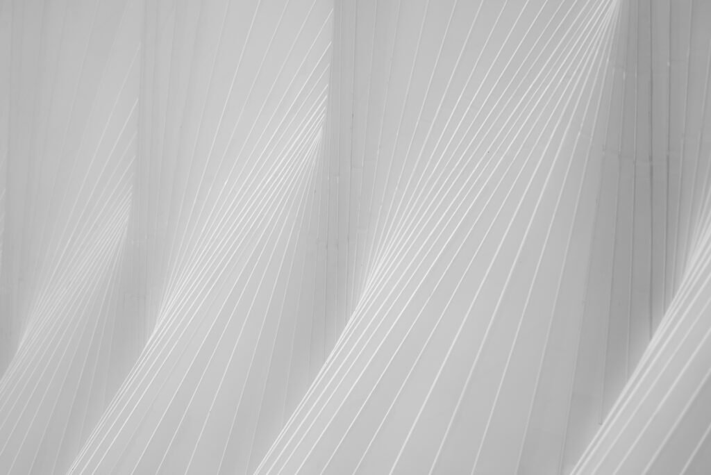 Abstrakte Architekturfotografie einer weißen Fassade mit fächerartigen, dynamischen Linienstrukturen