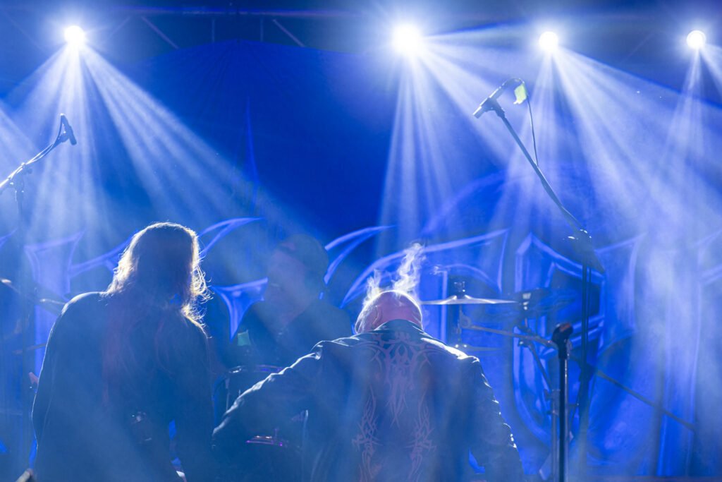Epische Rückansicht der Musiker auf der in kühles, blaues Licht getauchten Bühne. Fotografie: Roland Seichter.