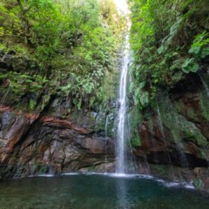 Das Wandbild 25 Fontes zeigt den berühmten Wasserfall auf Madeira, der über moosbewachsene Klippen in eine smaragdgrüne Lagune stürzt