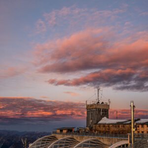 Fotokunst Der Mond über allem Zugspitze: Hochkant-Aufnahme von Glas- und Stahlarchitektur vor Morgenrot und Mond.