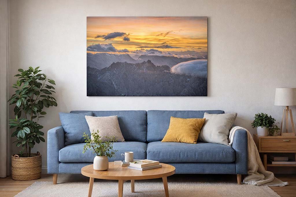 Das Wandbild Fotokunst Der Tag beginnt Zugspitze über einem Sofa in einem modern eingerichteten Wohnzimmer.
