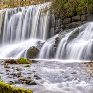 Das Wandbild Geratser Wasserfall zeigt die kaskadenartigen Wasserläufe des Allgäuer Wasserfalls in einer sanften Langzeitbelichtung