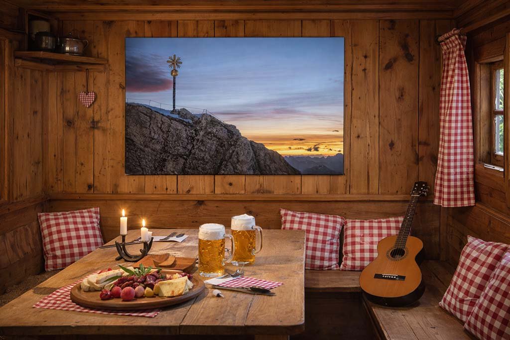 Das Wandbild Fotokunst Gipfelkreuz Zugspitze in der rustikalen Einrichtung einer Berghütte.