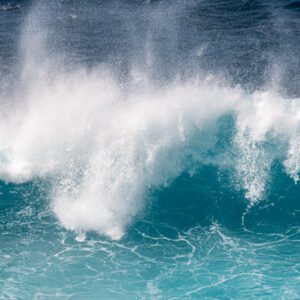 Das Wandbild Türkise Gischt zeigt eine kraftvolle, aufpeitschende Meereswelle in leuchtendem Türkis mit weißer, dynamischer Gischtkrone