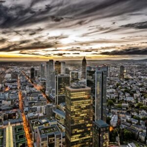 Das Panorama-Wandbild Frankfurter Abendspektakel zeigt die weitläufige, beleuchtete Skyline von Frankfurt am Main unter einem dramatischen Wolkenhimmel.