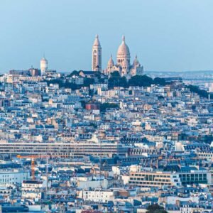 Das Panorama-Wandbild Sacre Coeur zeigt die weiße Basilika auf dem Montmartre über dem dichten Häusermeer von Paris bei hellem Tageslicht.