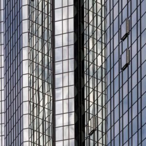 Das Wandbild Spiegelwand zeigt eine detailreiche Nahaufnahme einer modernen Glasfassade mit komplexen Spiegelungen im 3:2 Format.