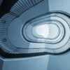 Das Wandbild Treppenhausgeometrie zeigt eine abstrakte Untersicht eines geschwungenen Treppenhauses in kühlen Blautönen im 3:2 Format.