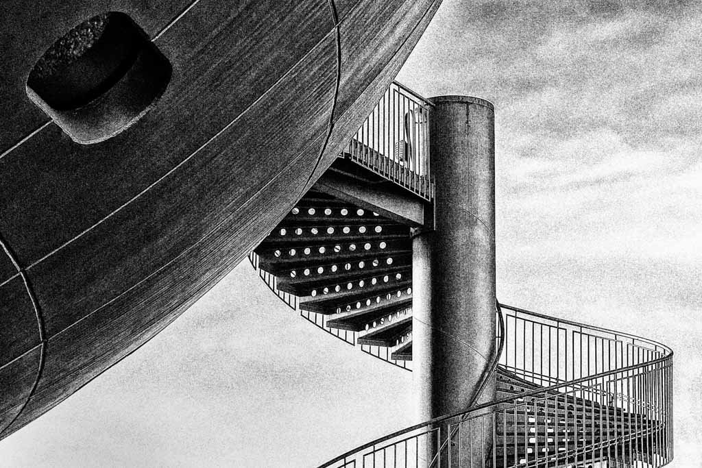 Das Wandbild Ufo zeigt eine abstrakte Schwarz-Weiß-Aufnahme einer futuristischen Wendeltreppe und einer kugelartigen Architektur im 3:2 Format.