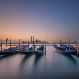 Panorama-Wandbild In der Lagune zeigt schaukelnde Gondeln in Venedig vor der Silhouette von San Giorgio Maggiore in der Abenddämmerung.