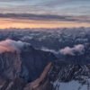Fotokunst Wattewolken Zugspitze: Schroffe Berggipfel im Morgenlicht mit sanften, rosafarbenen Wolkenformationen im Vordergrund.