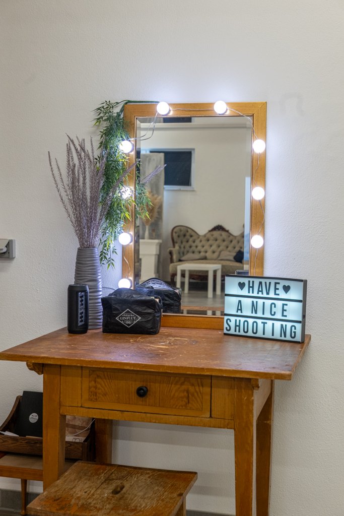 Schminktisch mit beleuchtetem Spiegel und Willkommens-Schild im Fotostudio Kaufbeuren-Neugablonz.