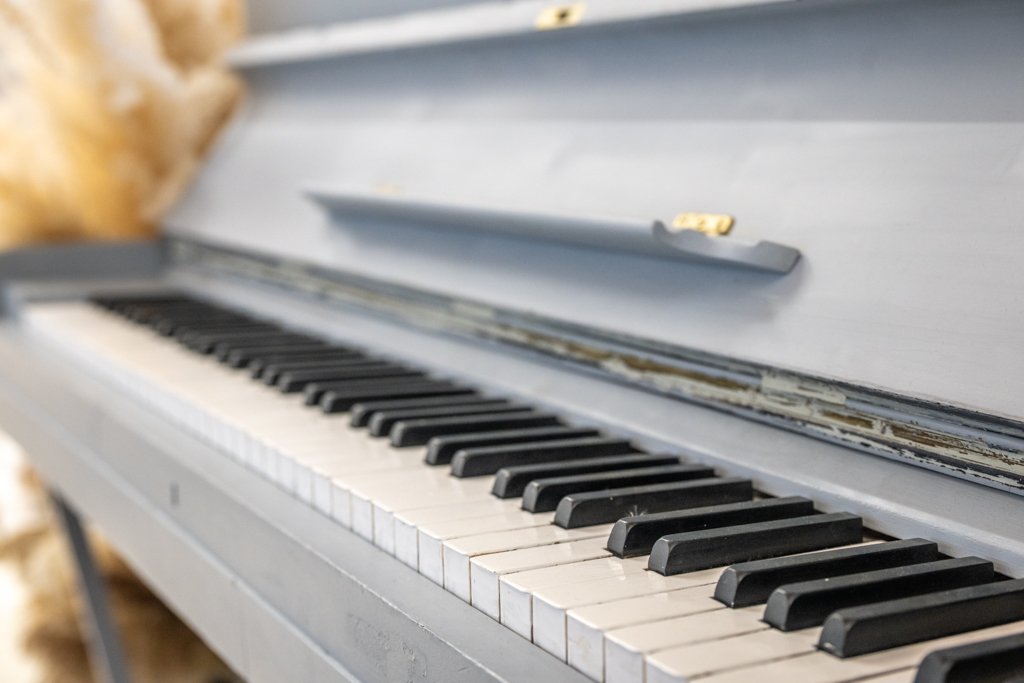 Detailaufnahme eines grauen Klaviers als Requisite für emotionale Portrait-Shootings im Fotostudio.