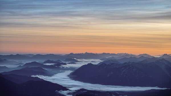 Blick von der Zugspitze auf Bergketten im Nebel bei Morgenstimmung – preisgekrönte Fotokunst von Roland Seichter.