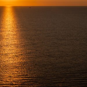 Minimalistische Fotografie Orange Water mit goldenen Sonnenreflexionen auf der Meeresoberfläche