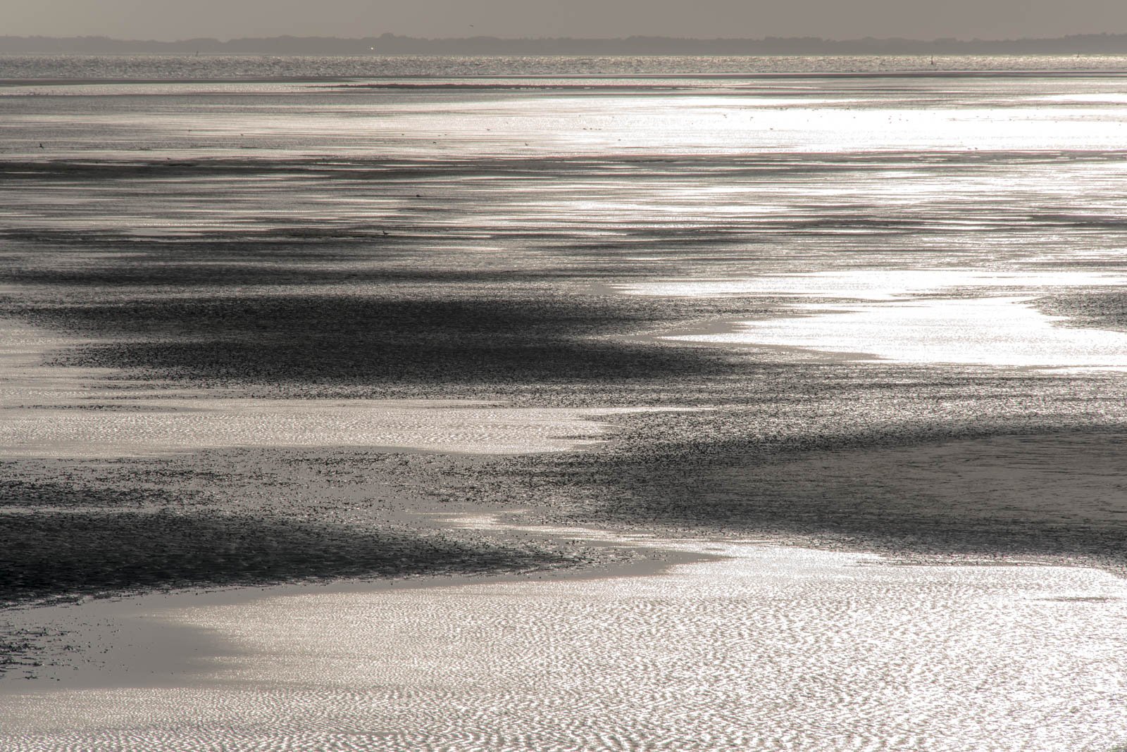 Reduzierte Atmosphäre von Wasser am Strand im Gegenlicht – minimalistisches Wandbild für Ruhe und Fokus.