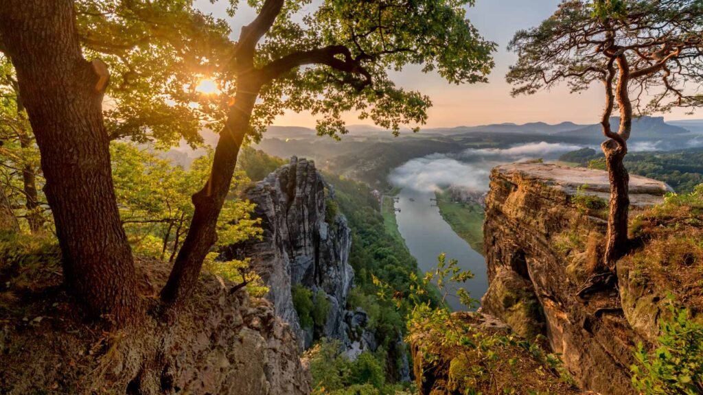 Spektakulärer Ausblick auf das neblige Elbtal in der Sächsischen Schweiz bei Sonnenaufgang.