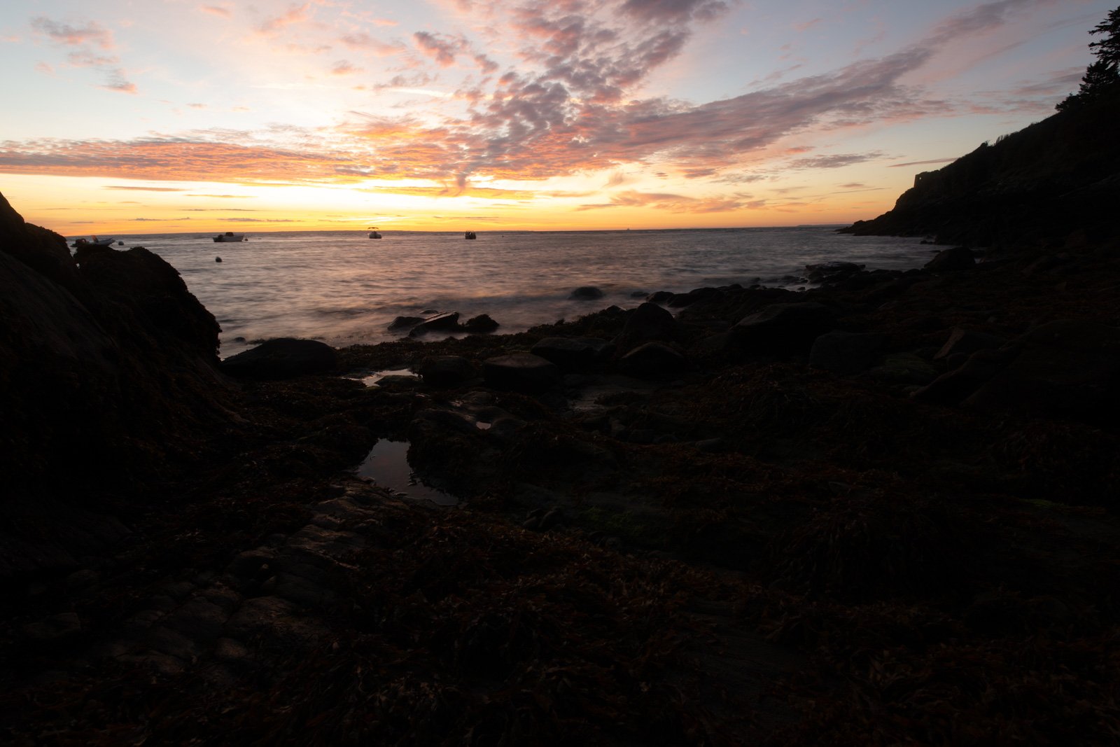 Unbearbeitetes RAW-Foto eines Sonnenaufgangs am Meer mit dunklem Vordergrund und hellem Himmel.