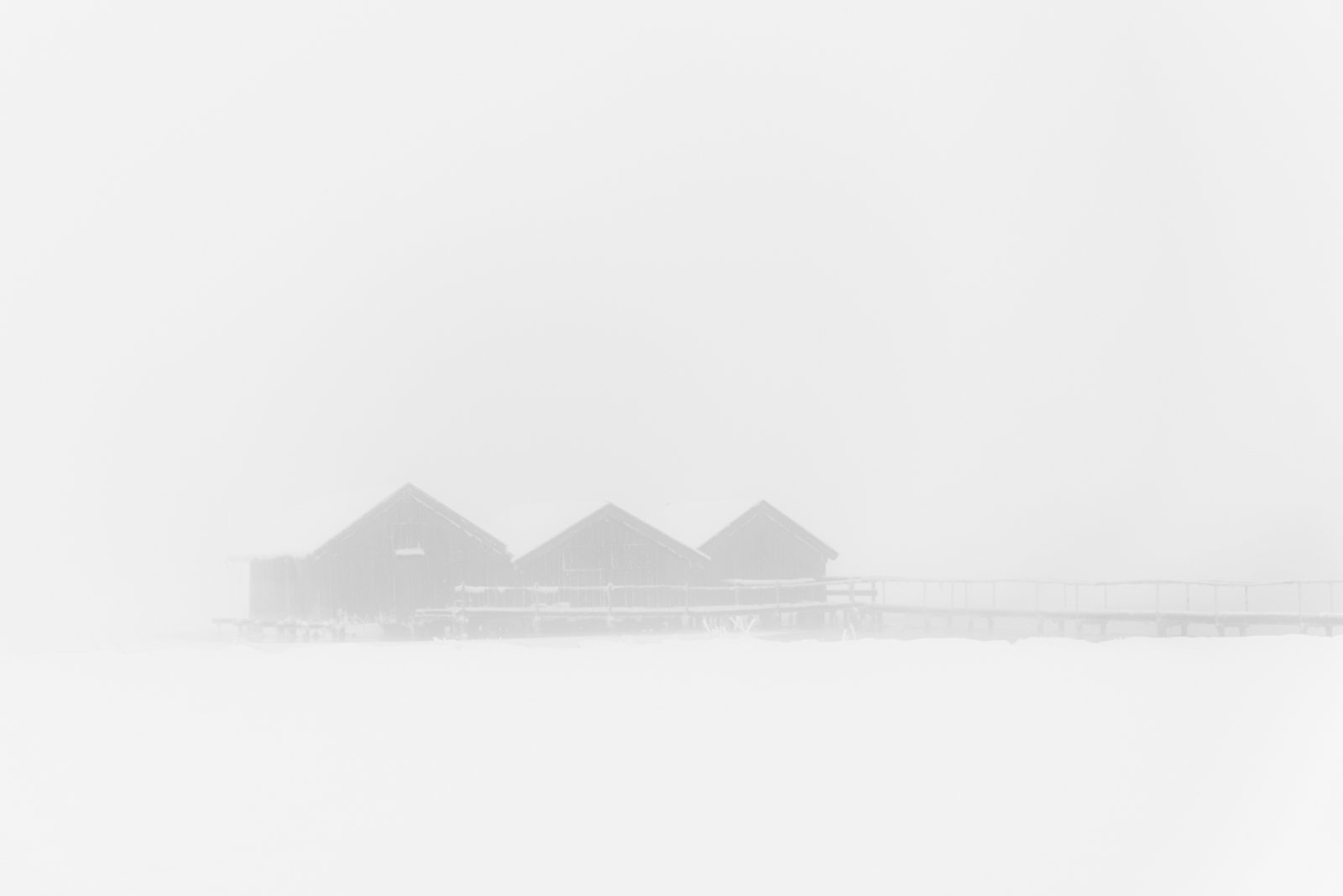 Zeitlose Schwarz-Weiß-Fotografie von Bootshäusern im Nebel, minimalistisches Design für moderne Innenarchitektur.