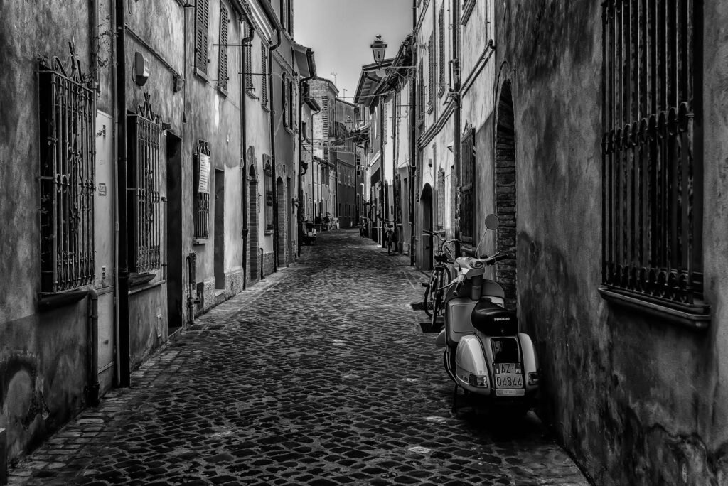 Blick in eine enge italienische Gasse mit Piaggio.