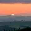 Das Wandbild Sonnenuntergang in der Toskana zeigt die glühende Abendsonne über den Hügeln im Format 2:1.