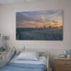 Das Wandbild Abendlicht im Panorama-Format an der Wand eines Patientenzimmers, das durch seine weite Perspektive eine beruhigende Wirkung entfaltet.