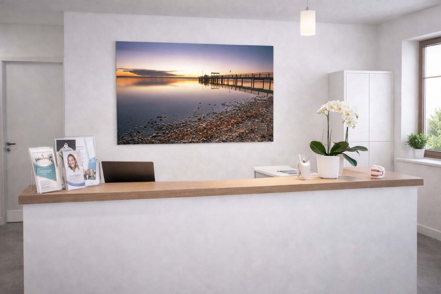 Das Wandbild Ammersee abends im 3:2 Format als beruhigender und stilvoller Blickfang im Empfangsbereich einer modern gestalteten Arztpraxis.