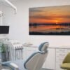 Das Wandbild Elbufer abends als beruhigender Blickfang in einem modernen Behandlungszimmer beim Zahnarzt