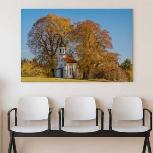 Herbstliche Kapelle Das Wandbild Herbstliche Kapelle im 3:2 Format als farbenfroher und beruhigender Blickfang an der Wand eines hell gestalteten Wartezimmers.